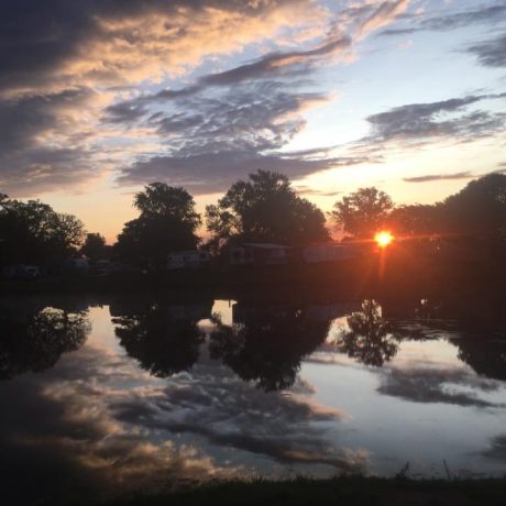 Beautiful sunrise view of the pond and RV sites at Shady Lakes RV Resort
