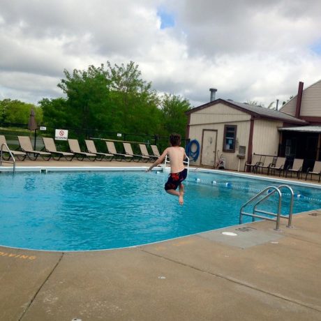 boy splashing in the pool at Shady Lakes RV Resort