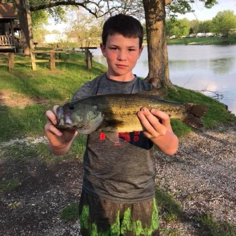 happy boy with a fish caught in the pond at Shady Lakes RV Resort