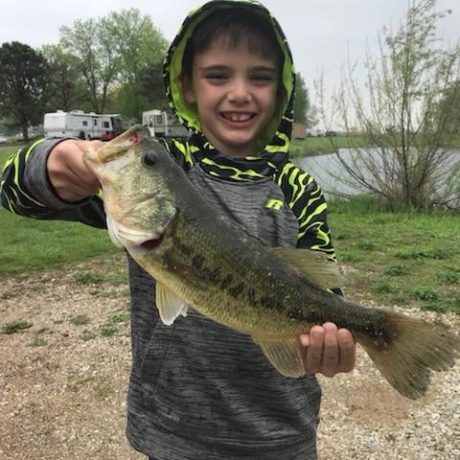 happy boy with a fish caught in the pond at Shady Lakes RV Resort