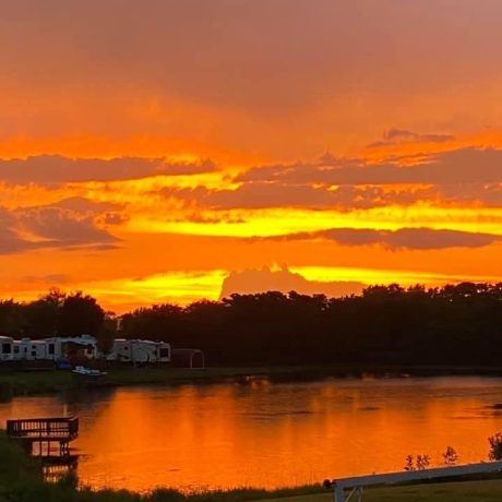 Beautiful sunset view of the pond and RV sites at Shady Lakes RV Resort