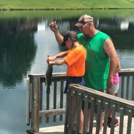 father and daughter fishing on pier